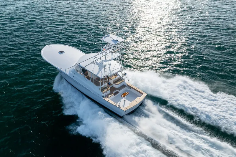 Slide: The Image of Custom Carolina East Bay 2001 yacht cruising on open water, creating a dynamic wake. - 9