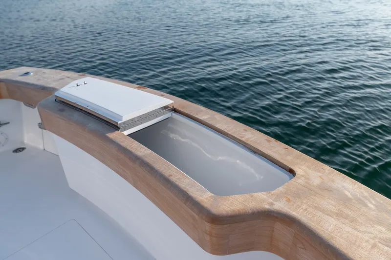 Slide: The Image of Custom Carolina East Bay 2001 boat deck with wooden trim and open storage compartment. - 29