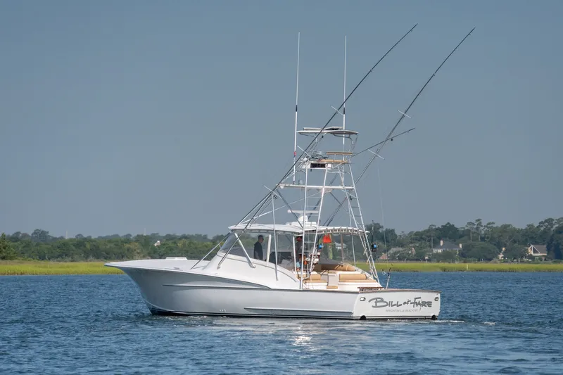 Slide: The Image of 2001 Custom Carolina East Bay boat on calm water with fishing rods. - 2