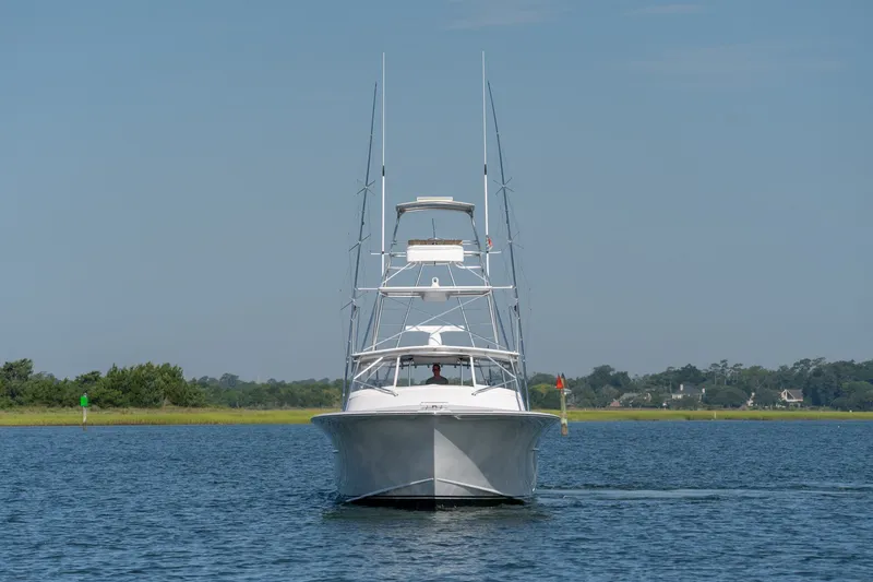 Slide: The Image of Custom Carolina East Bay 2001 yacht cruising on a calm waterway under a clear blue sky. - 6