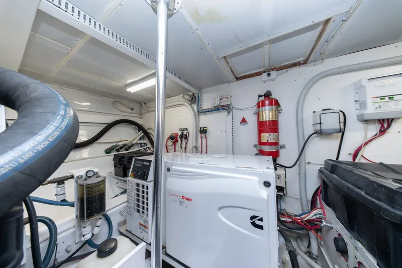 Slide: The Image of Engine room of 2001 Custom Carolina East Bay boat with Cummins Onan generator and fire extinguisher. - 53