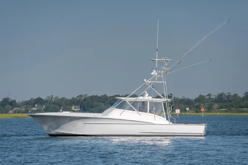 The Image of Custom Carolina East Bay 2001 boat cruising on a calm blue waterway. - 0