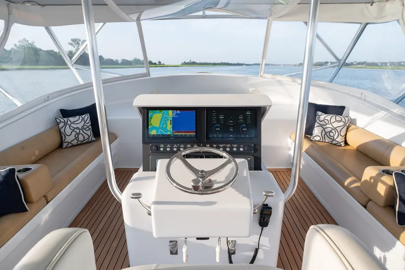 Slide: The Image of Helm of 2001 Custom Carolina East Bay boat with navigation screens and cushioned seating. - 20