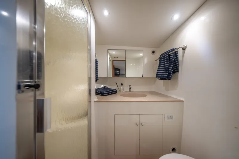 Slide: The Image of Bathroom interior of 2001 Custom Carolina East Bay yacht, featuring modern fixtures and striped towels. - 46