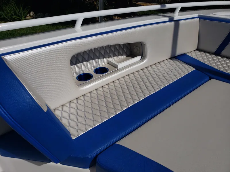 Slide: The Image of The image shows a luxurious boat seat with blue and white upholstery and cup holders. - 6