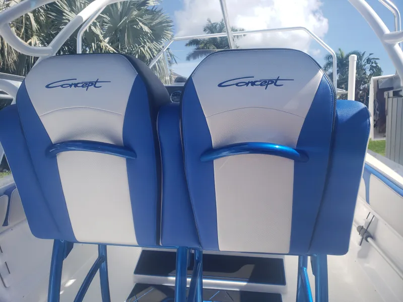 Slide: The Image of Two blue and white seats with "Concept" logo on a boat, surrounded by palm trees in the background. - 22