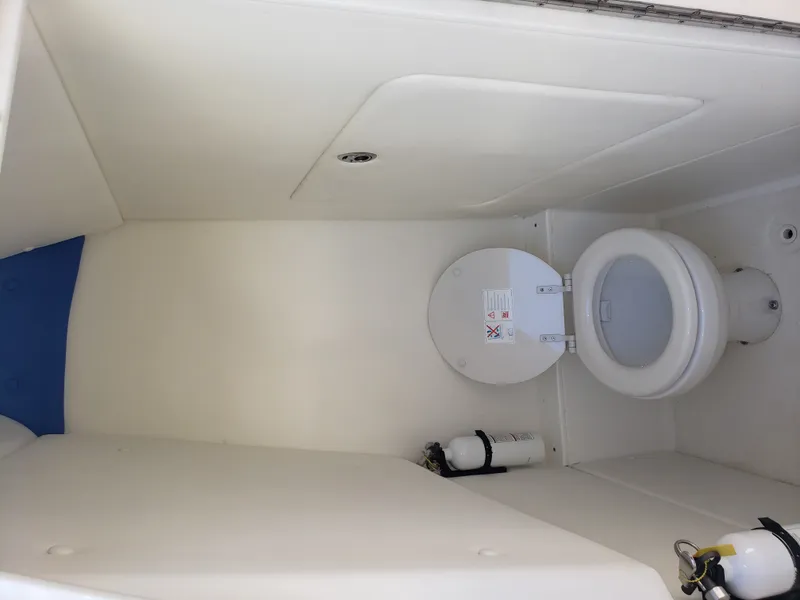 Slide: The Image of The image shows a clean, white boat toilet with a fire extinguisher on the wall. - 15