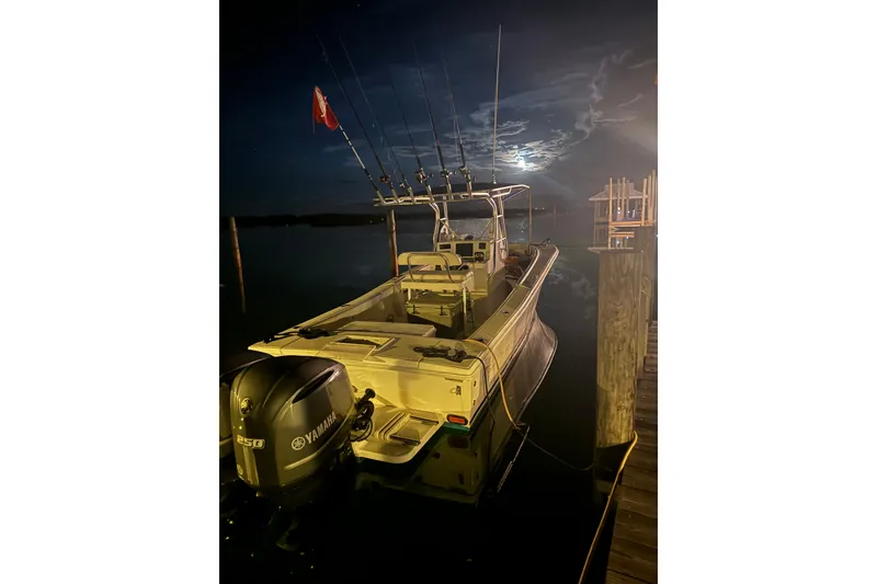 Slide: The Image of Ocean Runner 27 boat docked at night, illuminated by moonlight, with fishing rods visible. - 16