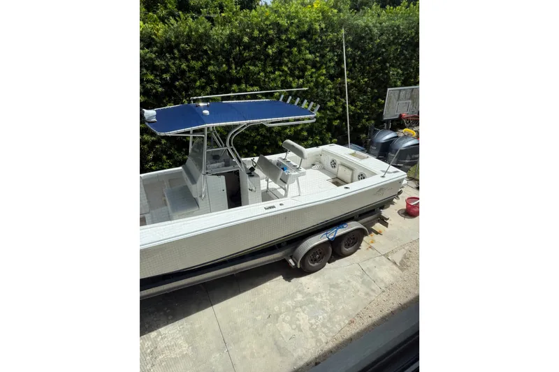 Slide: The Image of Ocean Runner 27 boat from 2000 on a trailer, parked outdoors. - 14