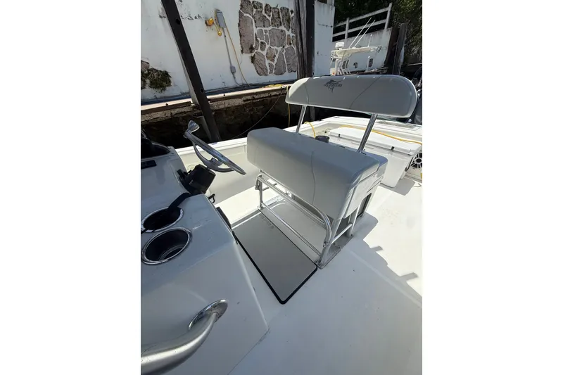 Slide: The Image of Interior view of a 2000 Ocean Runner 27 boat, featuring steering and seating area. - 13