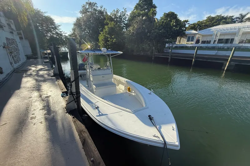 The Image of 2000 Ocean Runner 27 boat docked by a serene waterfront, surrounded by lush greenery. - 10