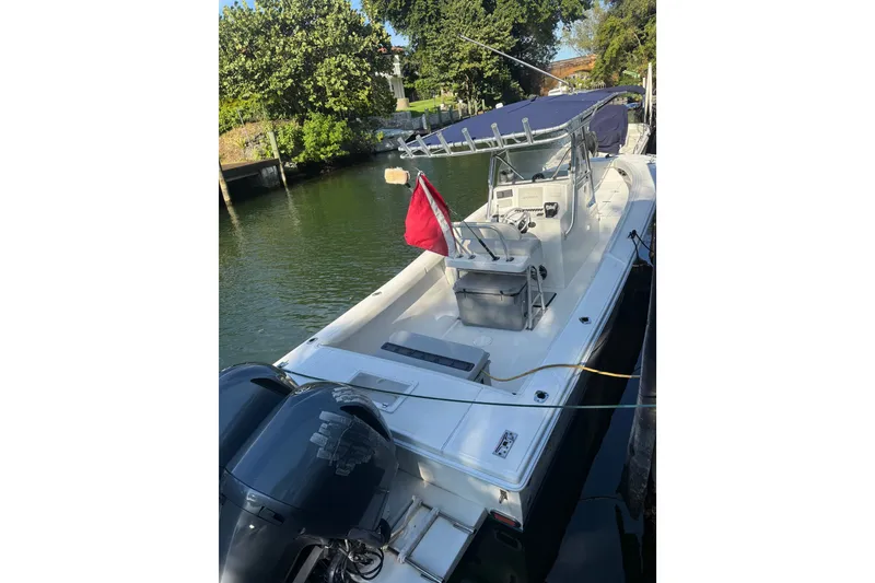 Slide: The Image of 2000 Ocean Runner 27 boat docked, featuring dual engines and a red flag. - 12