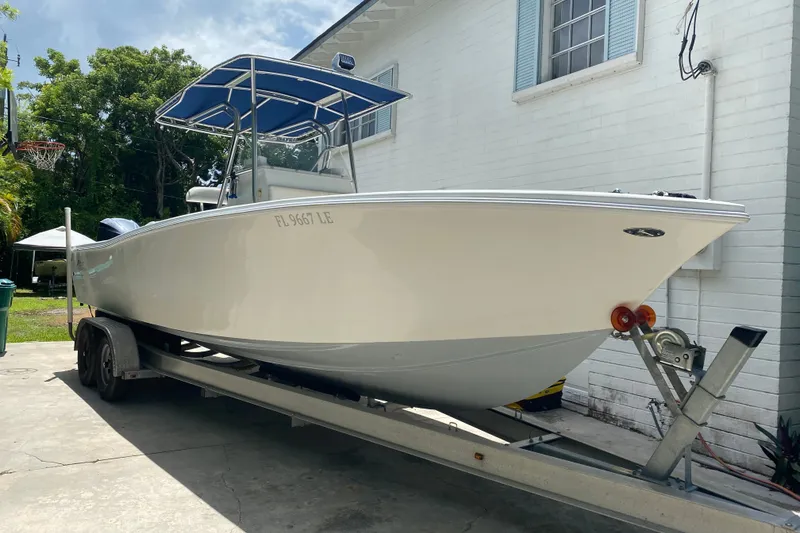 Slide: The Image of 2000 Ocean Runner 27 boat on trailer, parked beside a white building. - 8