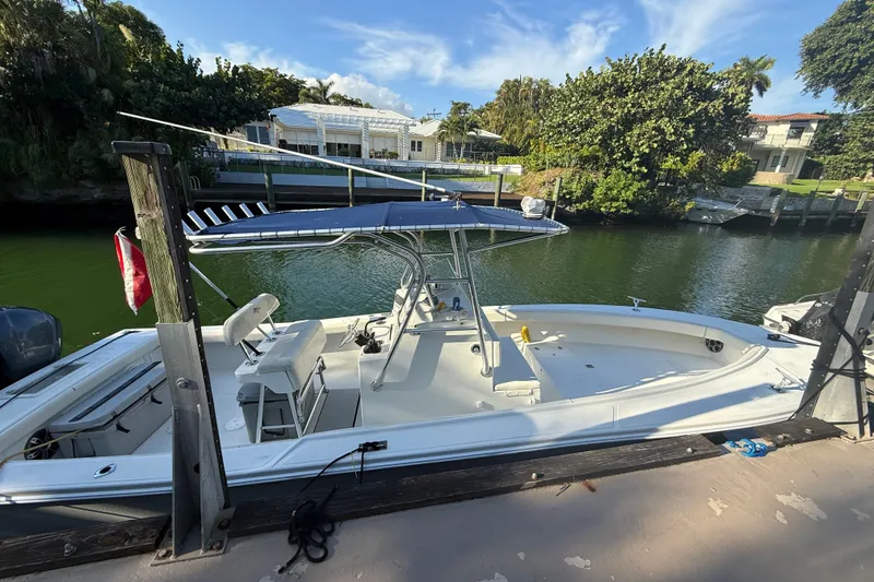 Slide: The Image of 2000 Ocean Runner 27 boat docked by a lush, green waterfront. - 11
