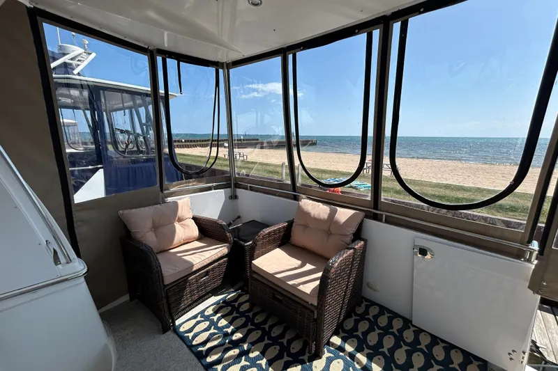 Slide: The Image of Enclosed deck of 2002 Carver 366 Motor Yacht with wicker chairs and ocean view. - 20