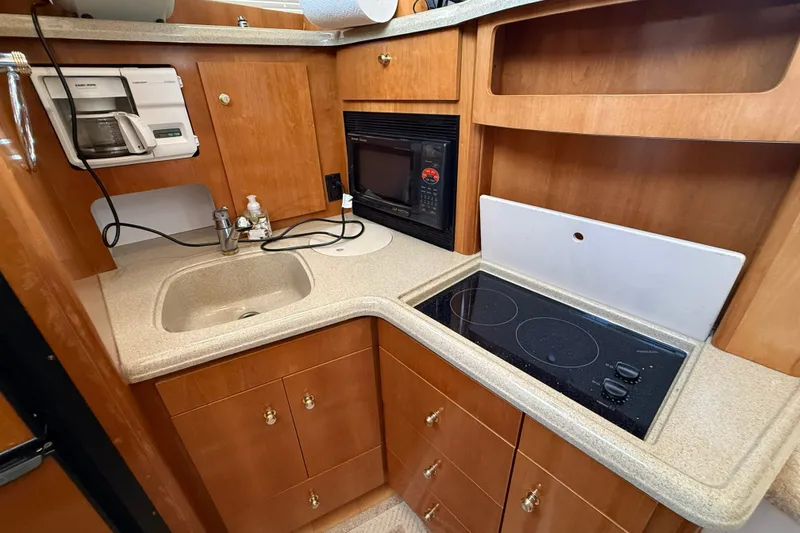 Slide: The Image of 2002 Carver 366 Motor Yacht kitchen with sink, stove, microwave, and coffee maker. - 25