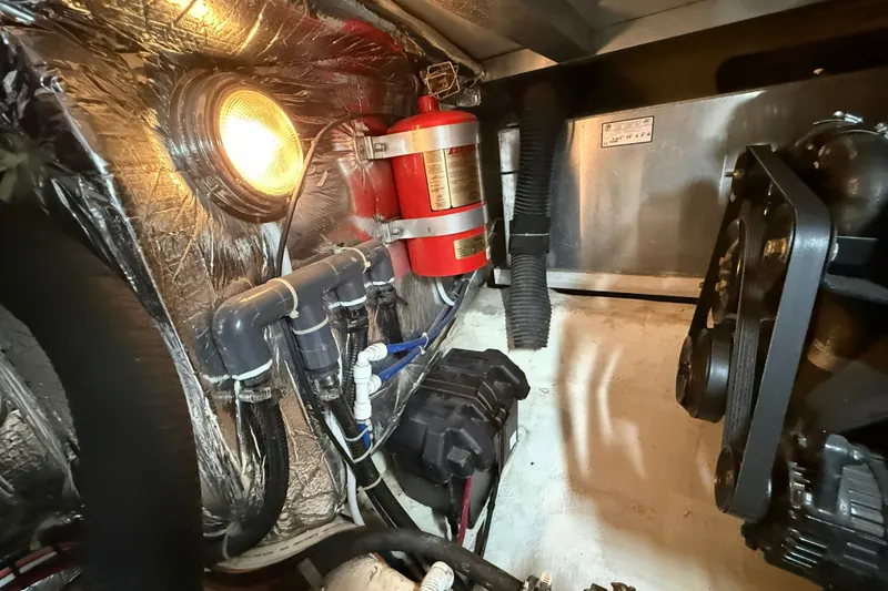 Slide: The Image of Engine room of 2002 Carver 366 Motor Yacht with fire extinguisher and mechanical components. - 31