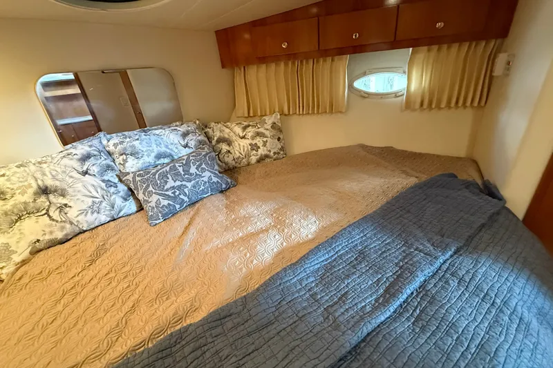 Slide: The Image of Cozy bedroom interior of 2002 Carver 366 Motor Yacht with elegant bedding and wooden cabinets. - 30