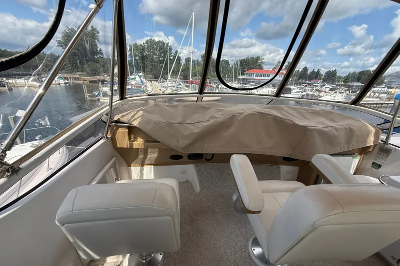 Slide: The Image of Interior view of 2002 Carver 366 Motor Yacht helm with marina backdrop. - 14