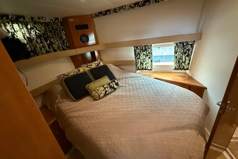 Slide: The Image of Cozy bedroom in 2002 Carver 366 Motor Yacht with patterned curtains and plush bedding. - 21
