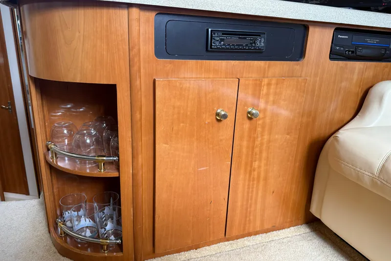 Slide: The Image of Interior of 2002 Carver 366 Motor Yacht with wooden cabinetry and glass storage. - 34