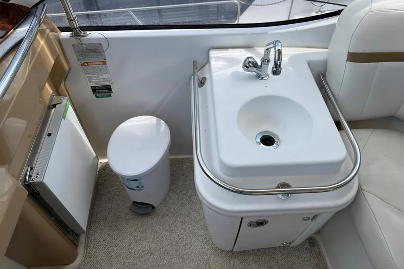 Slide: The Image of 2002 Carver 366 Motor Yacht interior with sink, trash bin, and seating area. - 16
