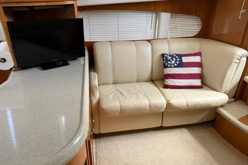 Slide: The Image of Interior of 2002 Carver 366 Motor Yacht with beige sofa and American flag pillow. - 32