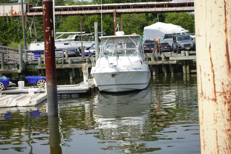 Slide: The Image of 2004 Grady-White Tournament 275 boat docked at a marina with surrounding vehicles. - 4