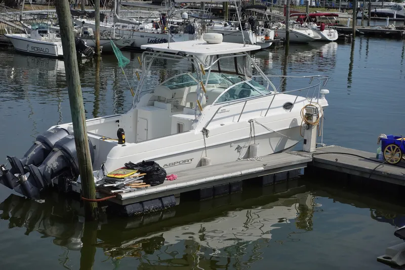 Slide: The Image of 2004 Grady-White Tournament 275 boat docked in a marina, surrounded by other vessels. - 1