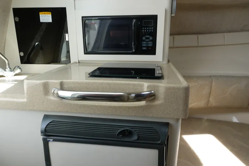 Slide: The Image of 2004 Grady-White Tournament 275 boat interior with microwave and kitchenette area. - 19