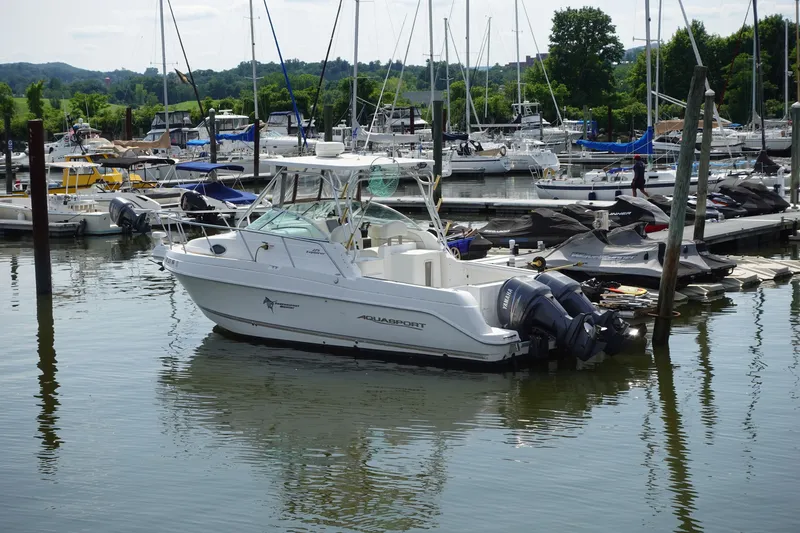 Slide: The Image of 2004 Grady-White Tournament 275 boat docked in a marina with other vessels. - 2