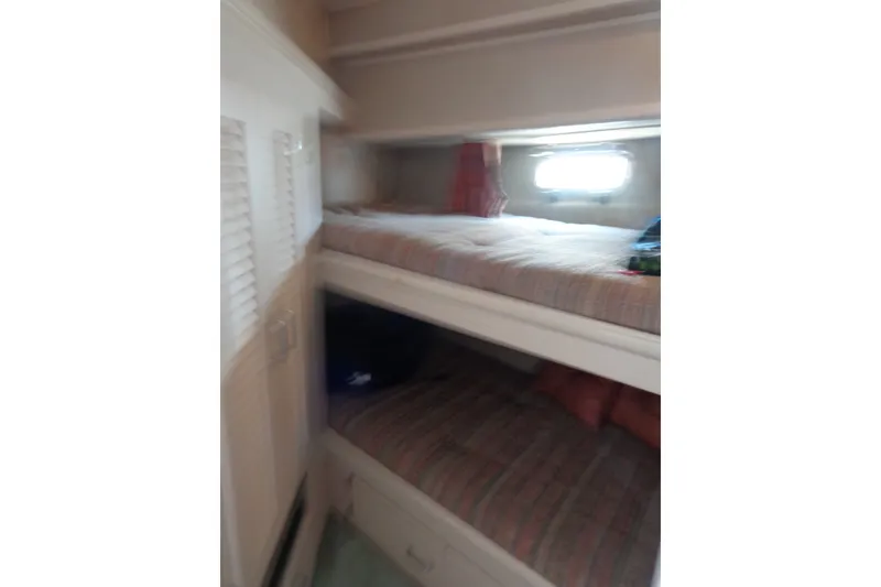 Slide: The Image of 1989 Tollycraft 34 Sport Sedan cabin with bunk beds and window. - 30