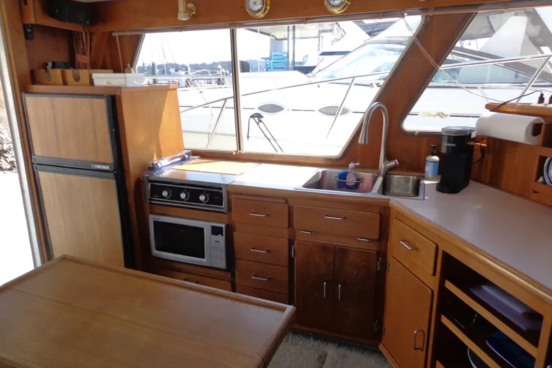 Slide: The Image of 1989 Tollycraft 34 Sport Sedan interior kitchen with wooden cabinetry and appliances. - 14