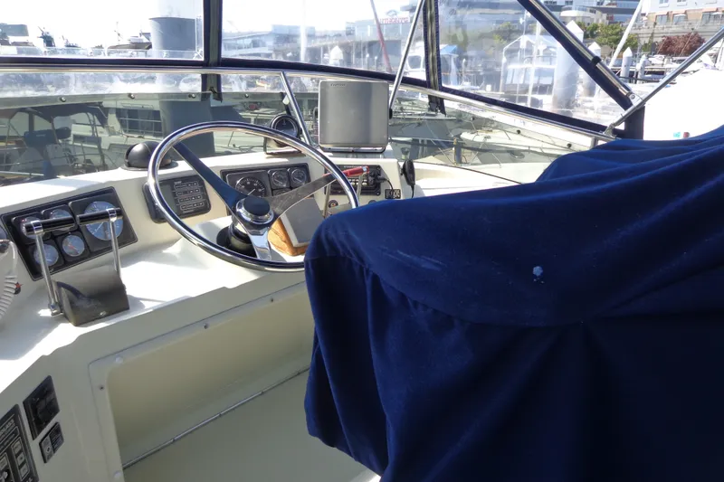 Slide: The Image of 1989 Tollycraft 34 Sport Sedan helm with steering wheel and navigation instruments. - 52