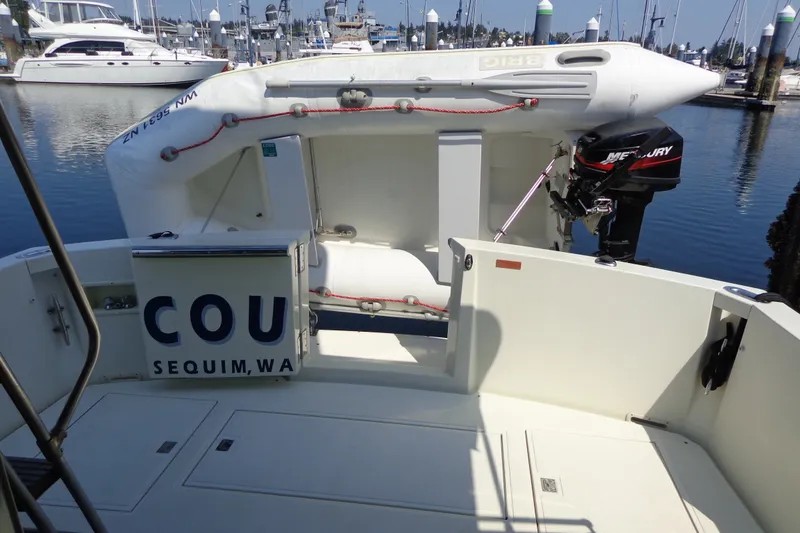 Slide: The Image of 1989 Tollycraft 34 Sport Sedan at marina with inflatable boat and Mercury outboard motor. - 33