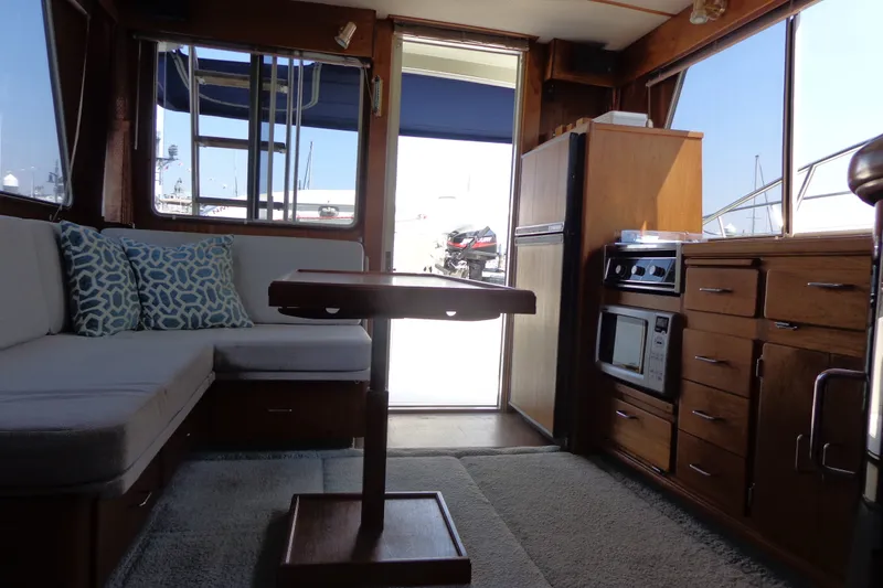 Slide: The Image of Interior of 1989 Tollycraft 34 Sport Sedan with cozy seating and wooden cabinetry. - 29