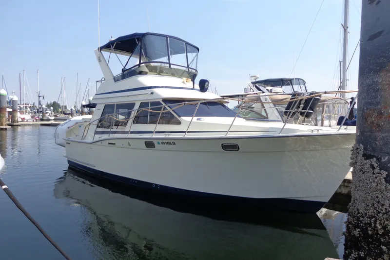 Slide: The Image of 1989 Tollycraft 34 Sport Sedan yacht docked in a marina, featuring a sleek design. - 61