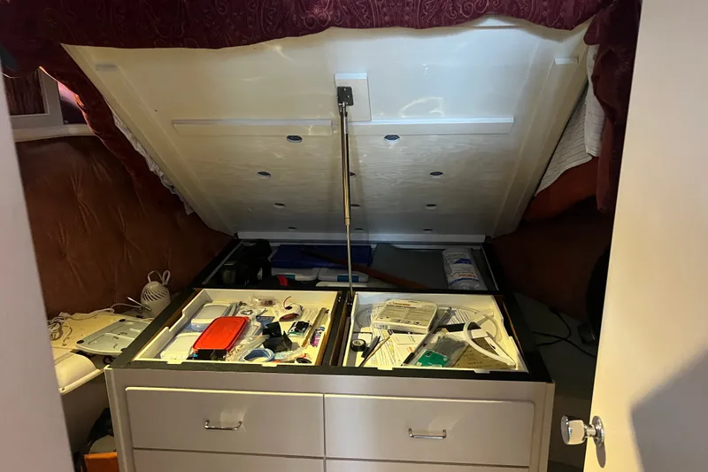 Slide: The Image of Open storage compartment in 1989 Tollycraft 34 Sport Sedan, revealing organized supplies and equipment. - 23