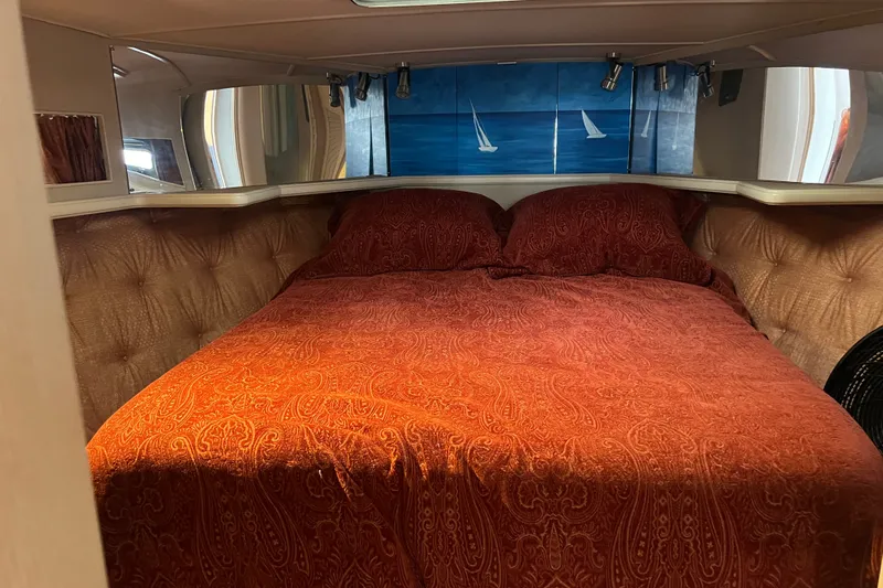 Slide: The Image of Cozy cabin interior of 1989 Tollycraft 34 Sport Sedan with red bedding and nautical decor. - 24