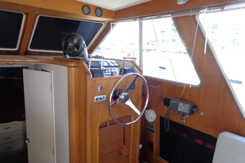 Slide: The Image of 1989 Tollycraft 34 Sport Sedan helm with wooden interior and navigation equipment. - 16