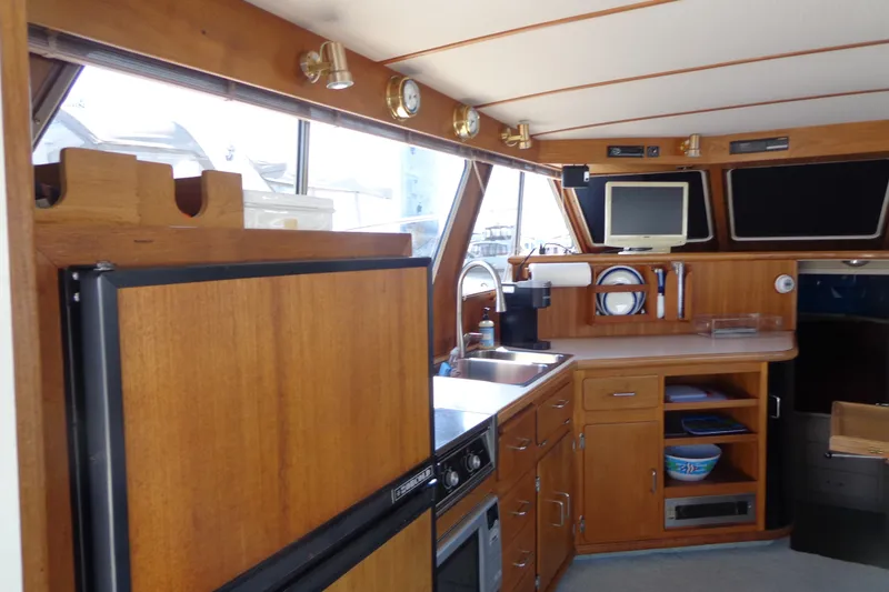 Slide: The Image of Interior of 1989 Tollycraft 34 Sport Sedan with wooden cabinetry and modern amenities. - 45