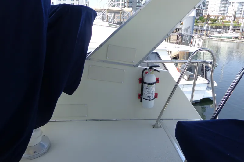 Slide: The Image of 1989 Tollycraft 34 Sport Sedan boat deck with fire extinguisher, docked at marina. - 51