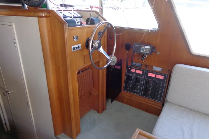 Slide: The Image of 1989 Tollycraft 34 Sport Sedan helm with wooden dashboard and control panels. - 35