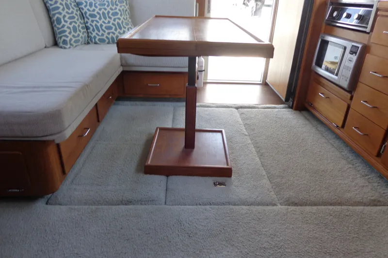 Slide: The Image of Interior of 1989 Tollycraft 34 Sport Sedan with wooden table and cushioned seating. - 32