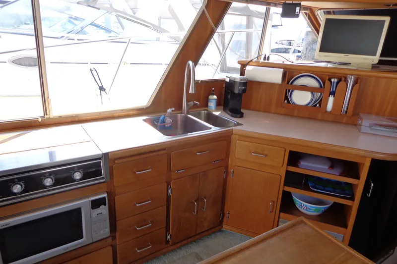 Slide: The Image of 1989 Tollycraft 34 Sport Sedan kitchen with wooden cabinetry, sink, and appliances. - 13