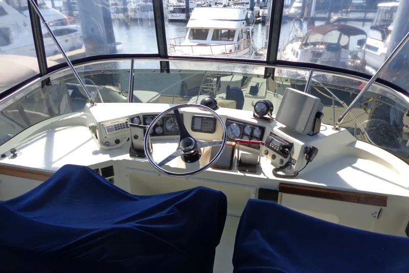 Slide: The Image of 1989 Tollycraft 34 Sport Sedan helm with marina view, featuring classic navigation instruments. - 49