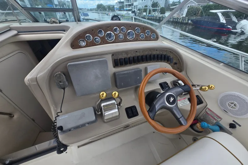 Slide: The Image of Cockpit of 2000 Sea Ray 290 Amberjack with steering wheel and control panel. - 13