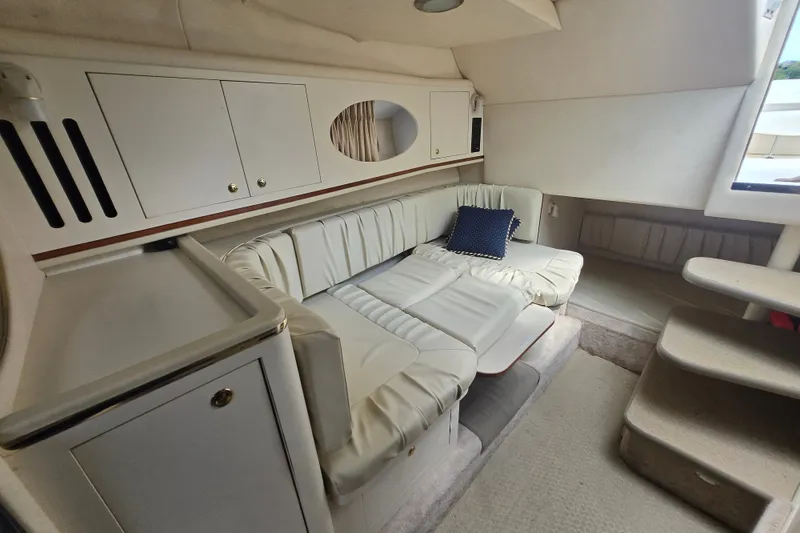 Slide: The Image of Interior of 2000 Sea Ray 290 Amberjack with white leather seating and cabinetry. - 8