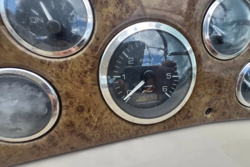 Slide: The Image of Close-up of 2000 Sea Ray 290 Amberjack dashboard gauges, featuring RPM and trim indicators. - 23