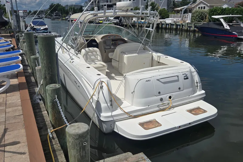 The Image of 2000 Sea Ray 290 Amberjack docked at a marina, showcasing its sleek design and spacious deck. - 0